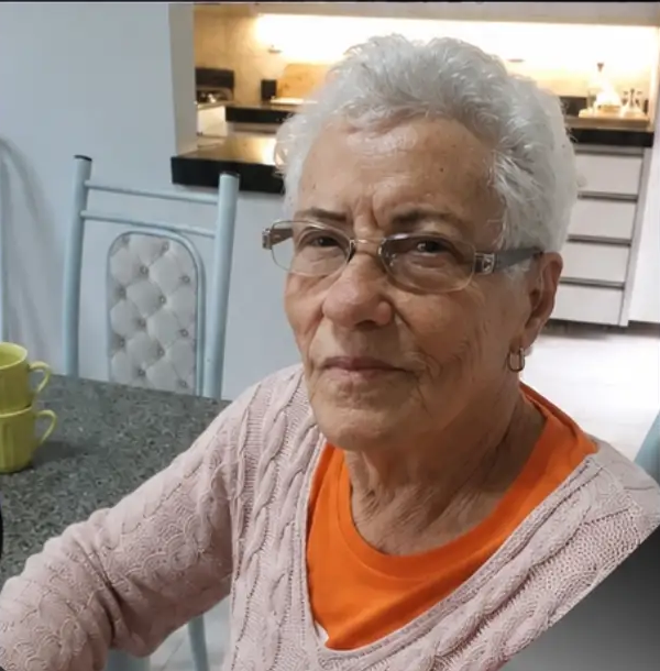 Retrato de Eva Sudária Ferreira, moradora de Patrocínio, sentada à mesa de casa