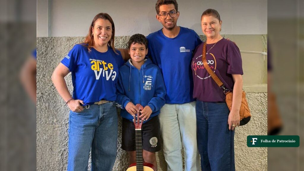 Aluno e equipe do Programa Arte Viva em Patrocínio posam com o violão entregue ao menino