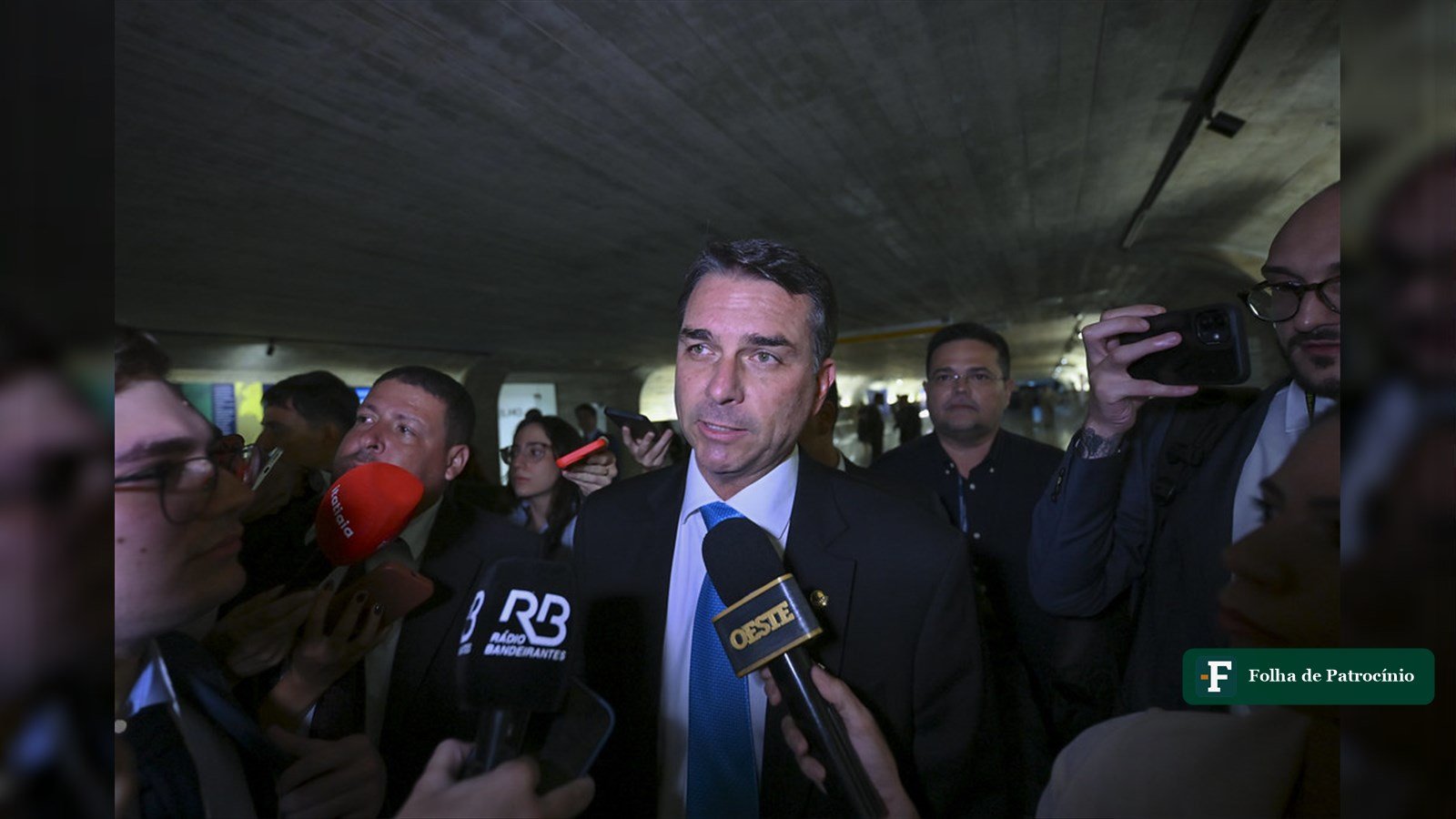 Senador Flávio Bolsonaro cercado por jornalistas durante entrevista sobre a candidatura de Flávio Bolsonaro à Presidência