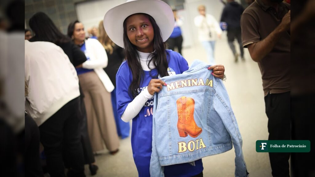 Menina da Bota Maria José Mendes segura jaqueta personalizada em convenção