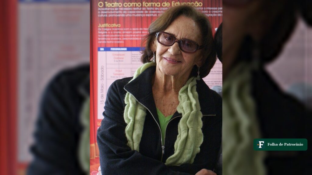 Retrato de Laura Cardoso, atriz de óculos escuros e cachecol verde, sorrindo