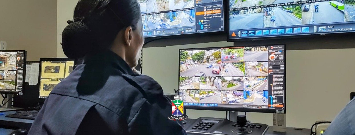 Central de videomonitoramento em Patrocínio com operadora diante de monitores que mostram ruas da cidade