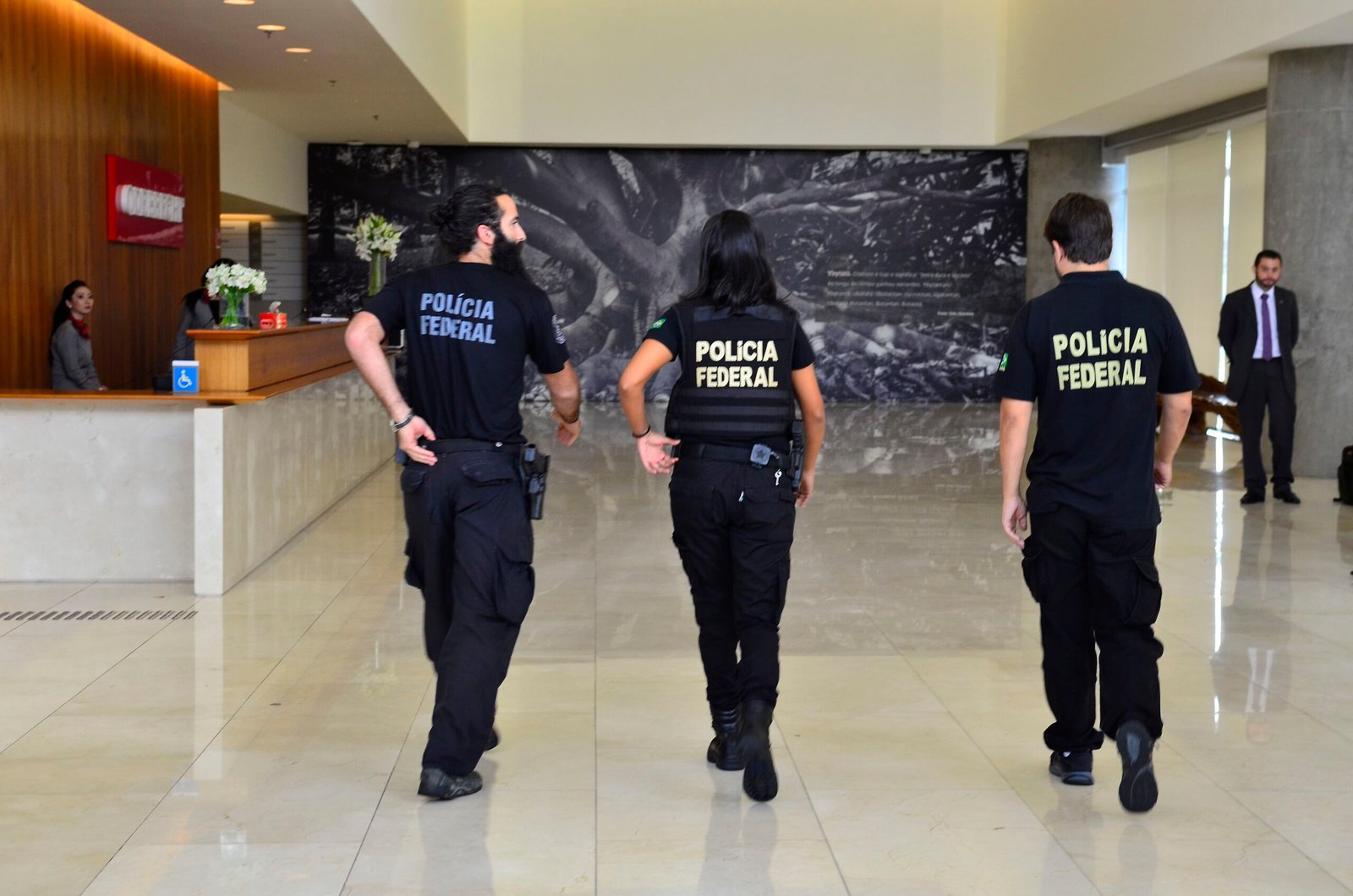 Agentes da Polícia Federal caminhando durante ação ligada a fraude no INSS em Minas Gerais