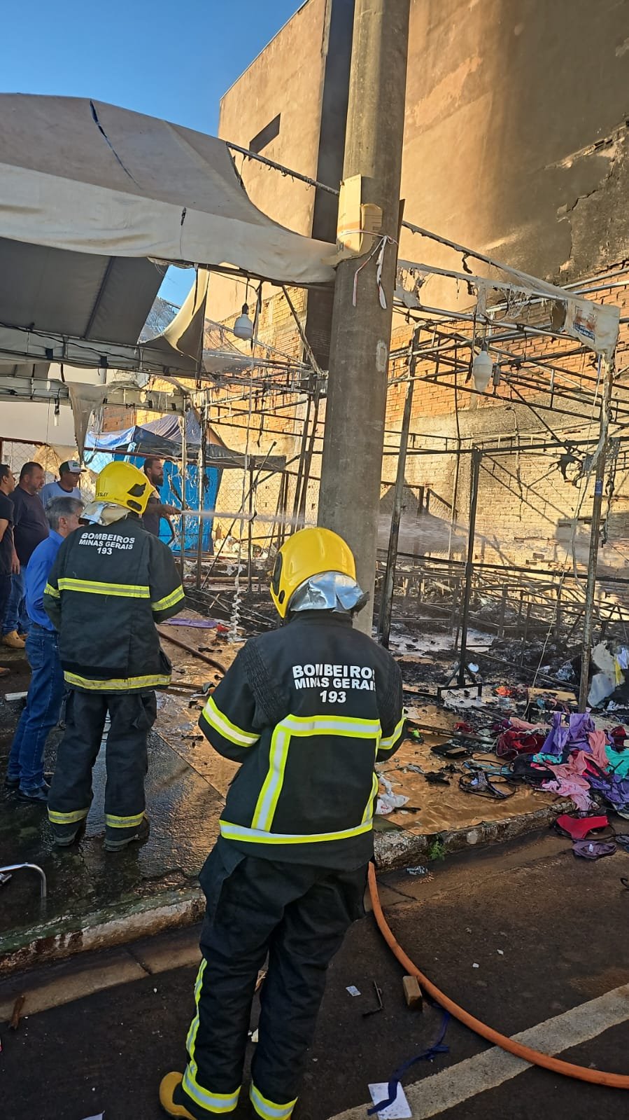 Militares do Corpo de Bombeiros no local do incêndio em Romaria, ao lado da estrutura queimada