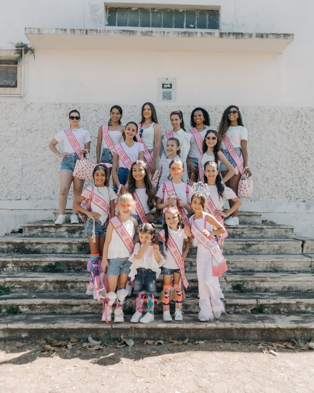 Grupo de candidatas do Pequena Miss Minas Gerais em escadaria de prédio histórico de Patrocínio
