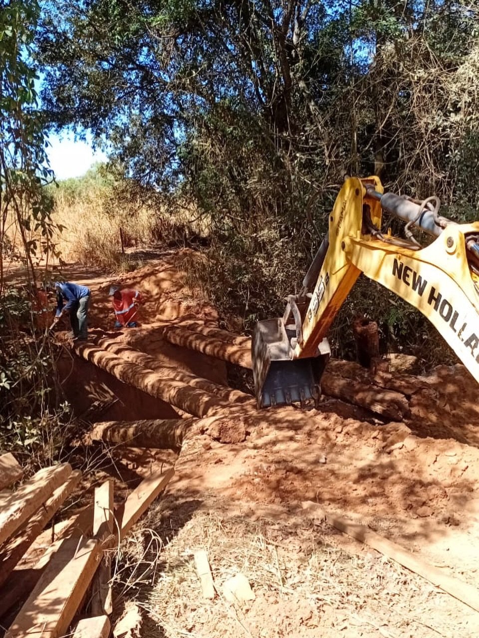 Trabalhadores e retroescavadeira na obra da ponte do Quebranzol