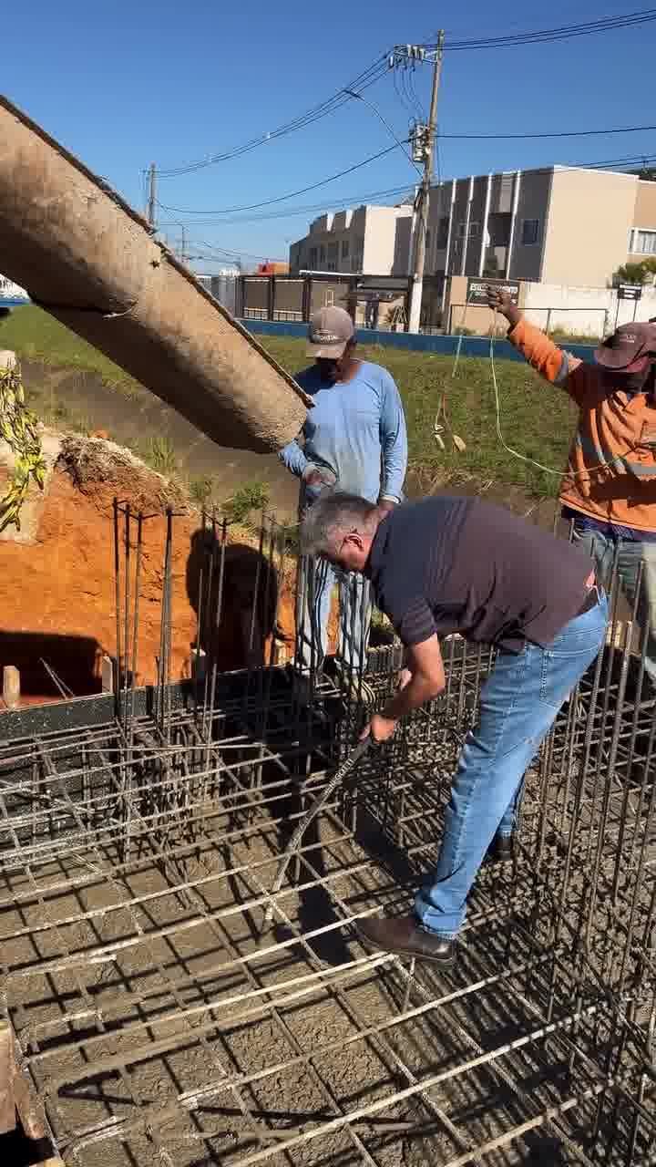 Trabalhadores despejam concreto sobre armação de ferragem na obra do pontilhão Cassimiro Santos, em Patrocínio