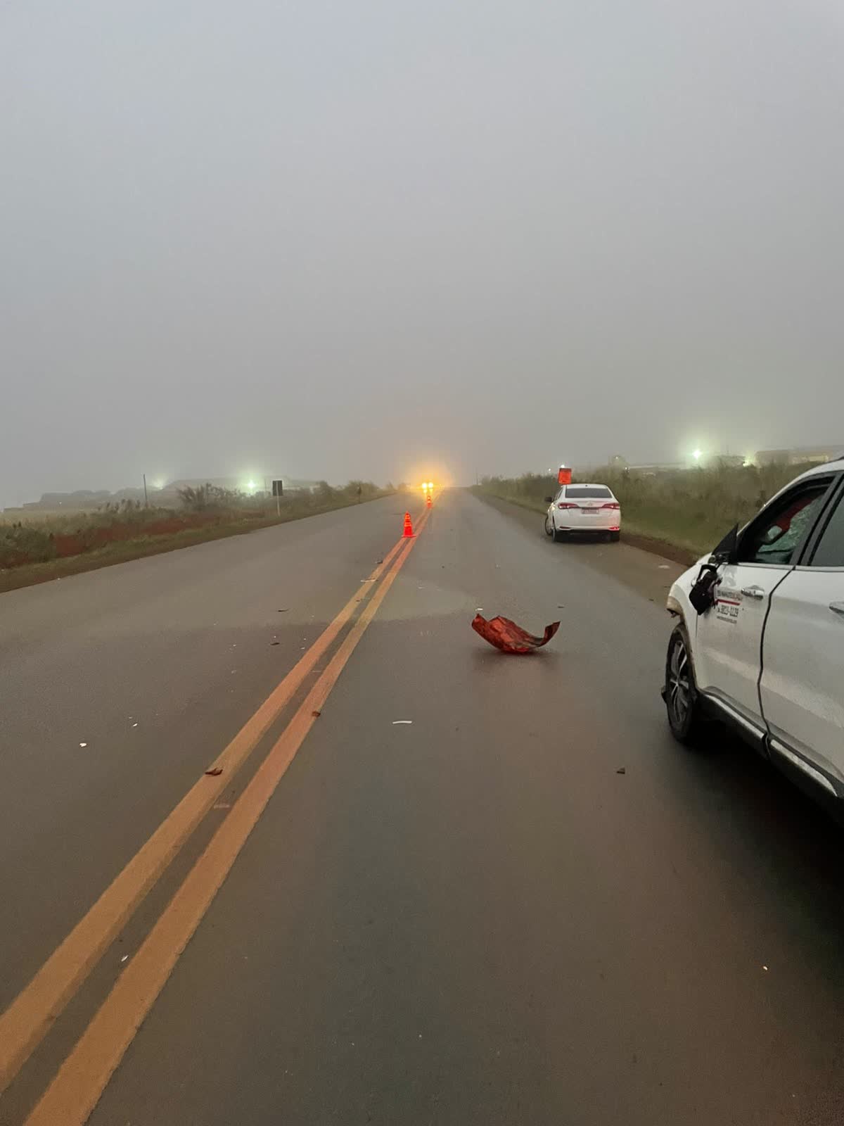 Cones de sinalização e picape Fiat Toro danificada na pista da BR-354 durante neblina após atropelamento em Rio Paranaíba