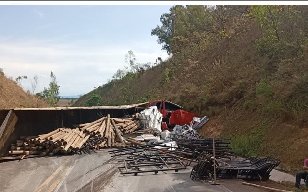 Carreta tomba na BR-365 e espalha toras de eucalipto e ferragens sobre a pista, em Patrocínio