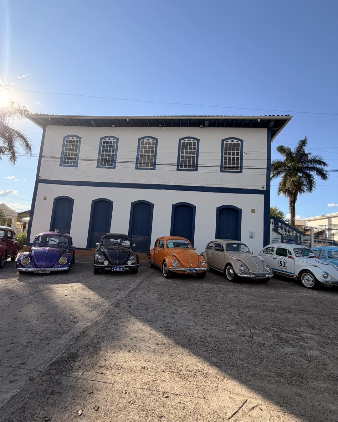 Fila de Fuscas coloridos do 3º Encontro de Carros Antigos em frente a prédio histórico de Patrocínio