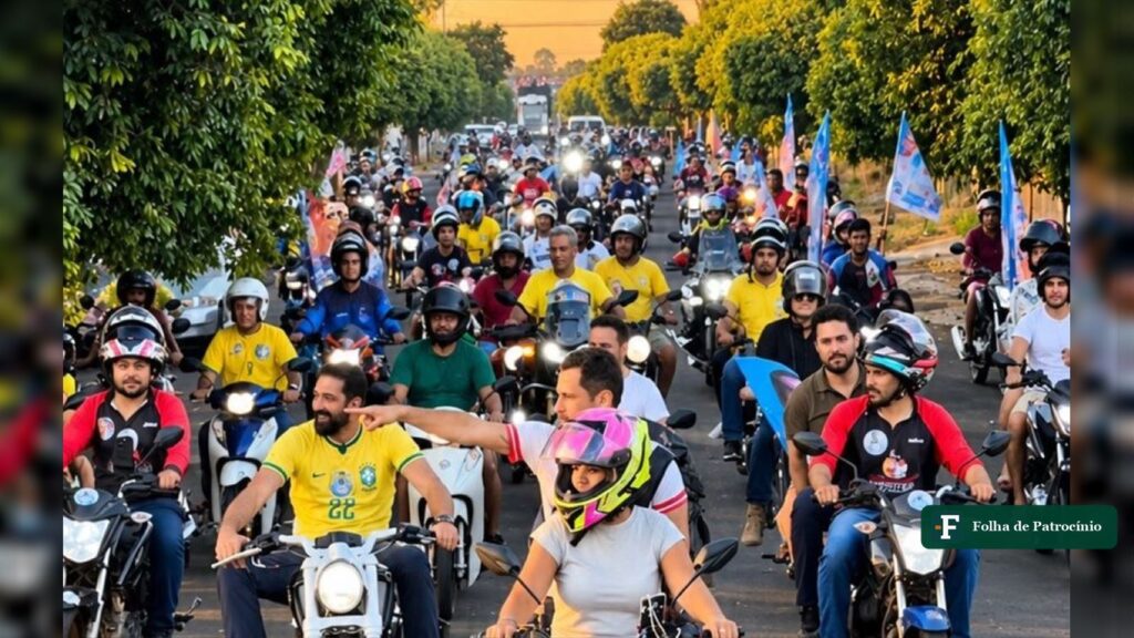 Motociata de campanha em Iturama, parada da agenda de Cleitinho no Triângulo Mineiro, com centenas de motos e bandeiras numa avenida arborizada
