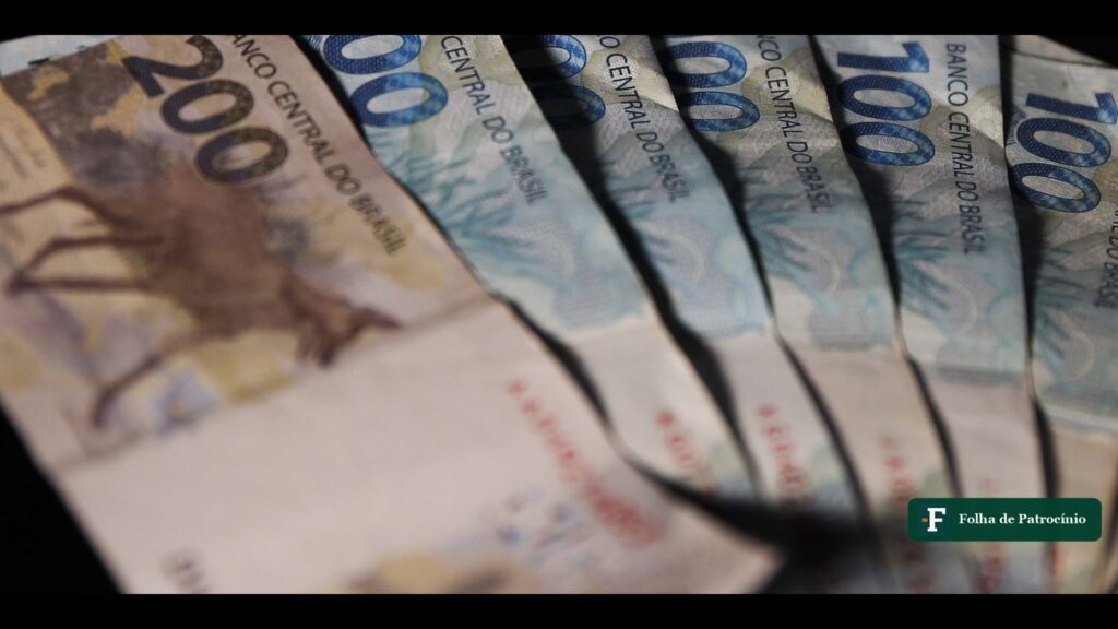 Cédulas de 200 e 100 reais enfileiradas, ilustrando os valores esquecidos do PIS/Pasep pagos pela Caixa. Foto: José Cruz/Agência Brasil