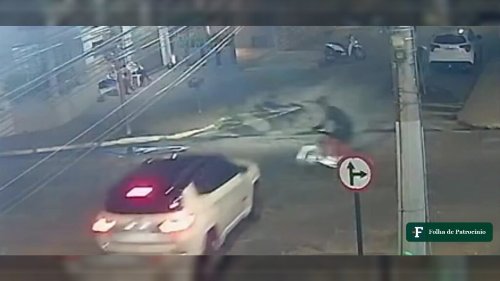 Imagem de câmera de segurança mostra o ciclista em Patos de Minas sendo arremessado com a bicicleta após a batida com um carro branco. Imagem: câmera de segurança/Reprodução
