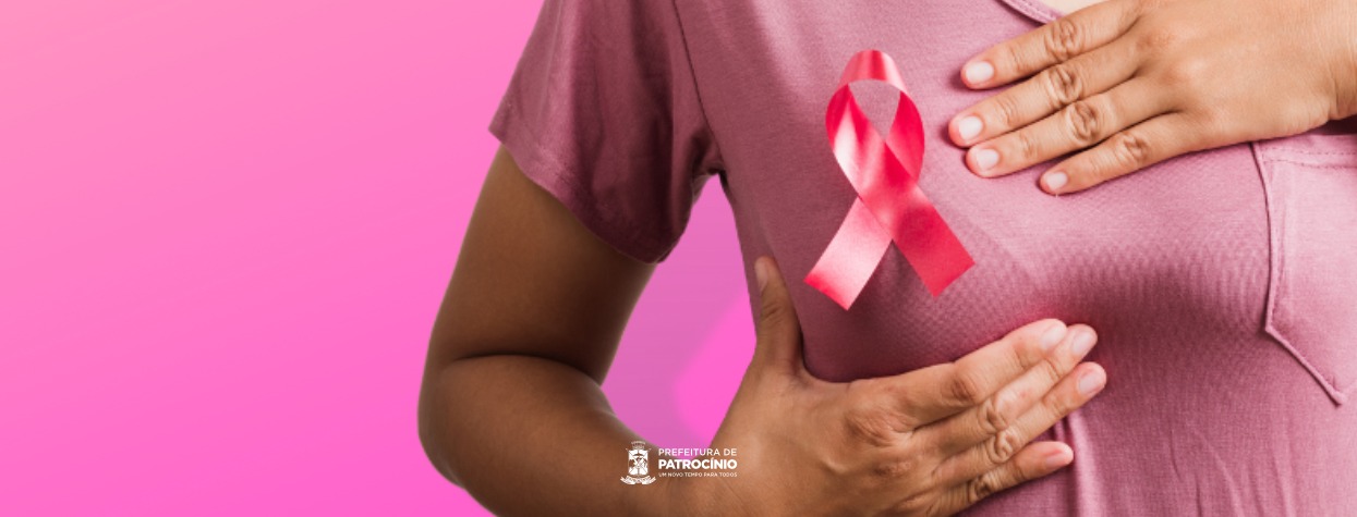 Mulher com laço rosa na blusa, imagem da campanha que anuncia o Implanon em Patrocínio