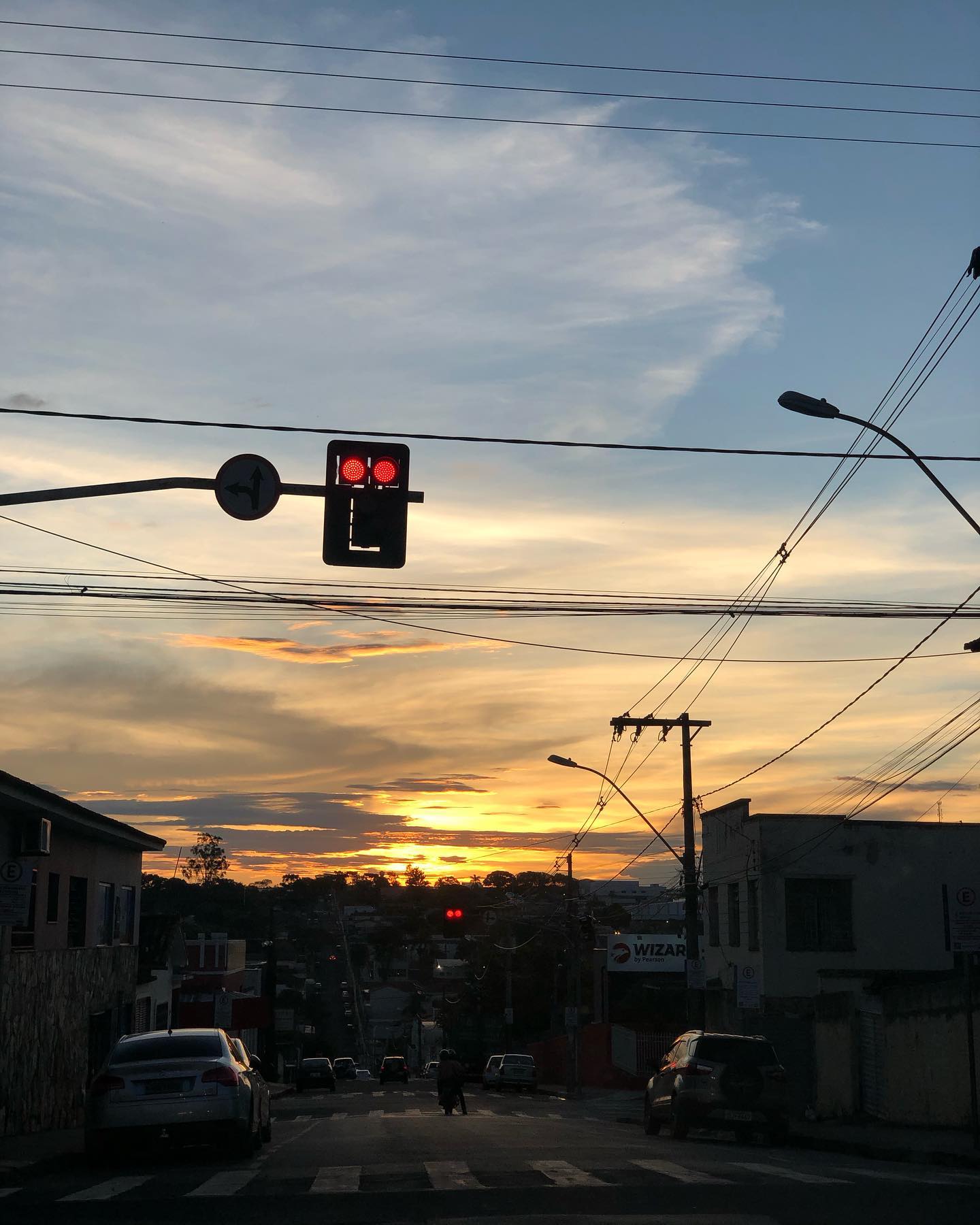 Rua de Patrocínio ao entardecer com moto parada no semáforo, cidade do encontro de motociclistas