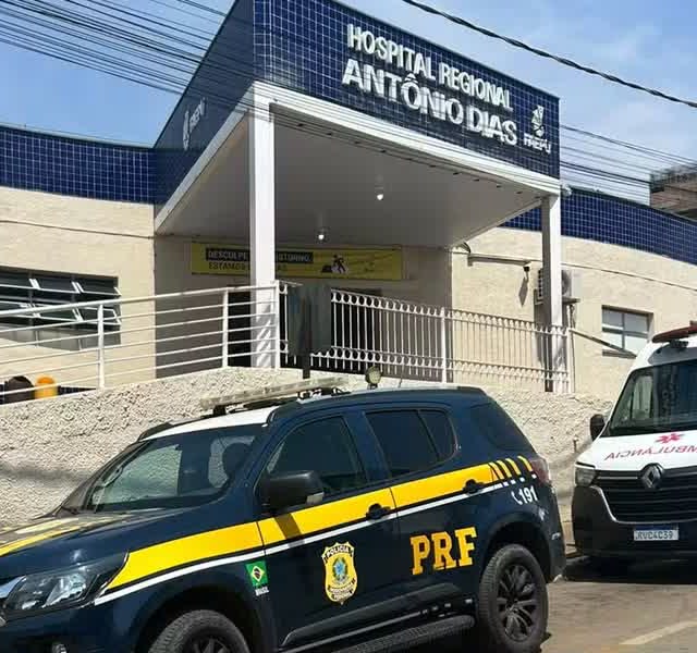 Fachada do Hospital Regional Antônio Dias com viatura da PRF e ambulância na porta, destino do socorro em que a PRF reanima trabalhador