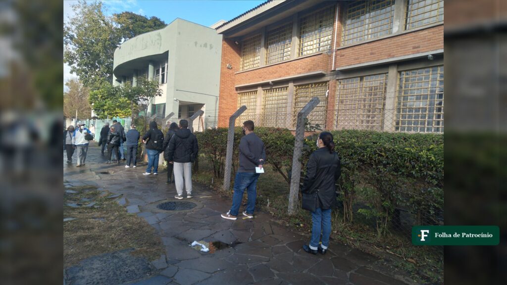 Fila de pessoas na calçada em frente a uma unidade básica de saúde, serviço onde atua o agente comunitário de saúde