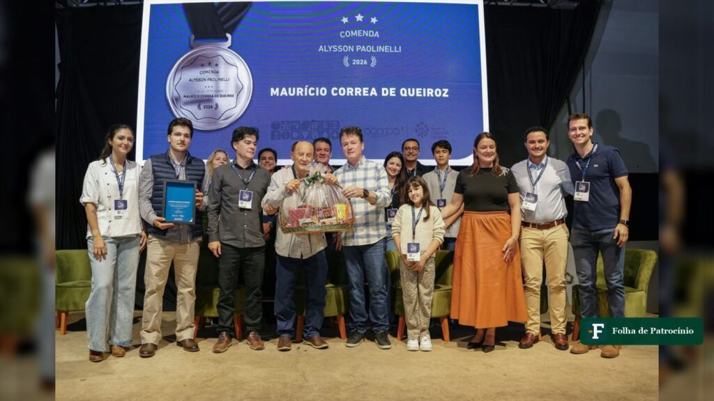 Entrega da Comenda Alysson Paolinelli no palco do Seminário do Café, com Maurício Corrêa de Queiroz, familiares e diretores da ACARPA diante do telão