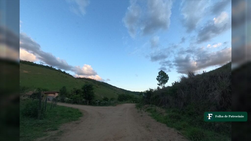 Estrada de terra entre pastos e uma casa simples na zona rural, rotina dos trabalhadores rurais