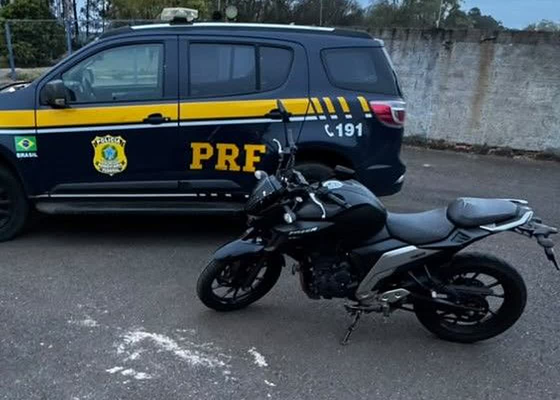 Viatura da PRF ao lado da moto com adulterações apreendida na BR-365, em Patos de Minas