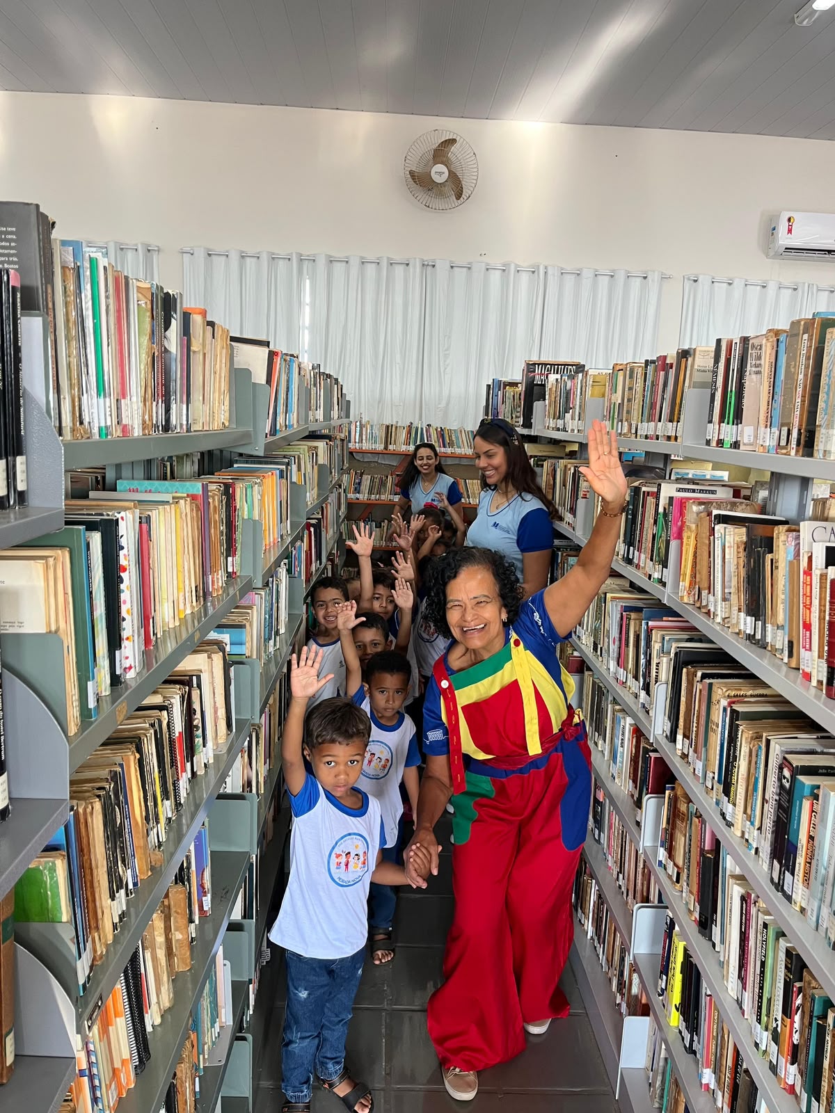 Crianças entre as estantes de livros da Biblioteca Pública Municipal de Patrocínio durante a Hora do Conto