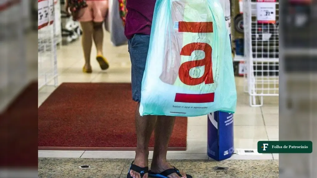 Cliente segura sacola com a logomarca da Americanas na entrada de uma loja da rede, cena da Black Friday da Americanas
