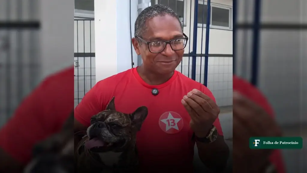 Eleitor leva cachorra para votar: homem de camisa vermelha com uma buldogue francesa no colo, na porta da seção