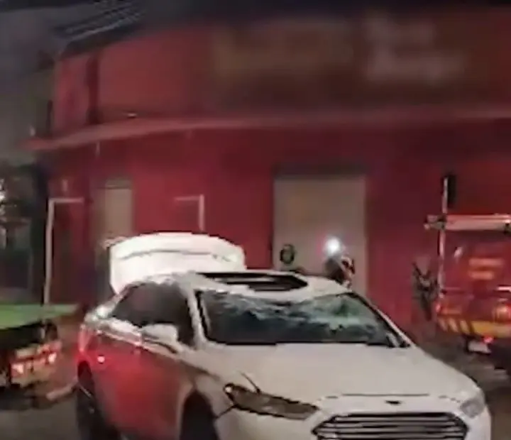 Carro branco com teto e para-brisa amassados depois do capotamento em Uberlândia, no bairro São Jorge