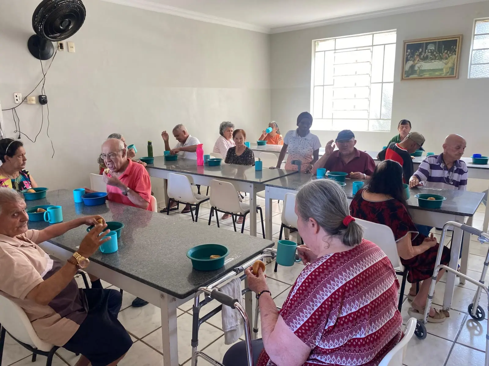 Idosos tomam café em mesa coletiva durante ação do Unicerp com a Casa do Idoso de Patrocínio