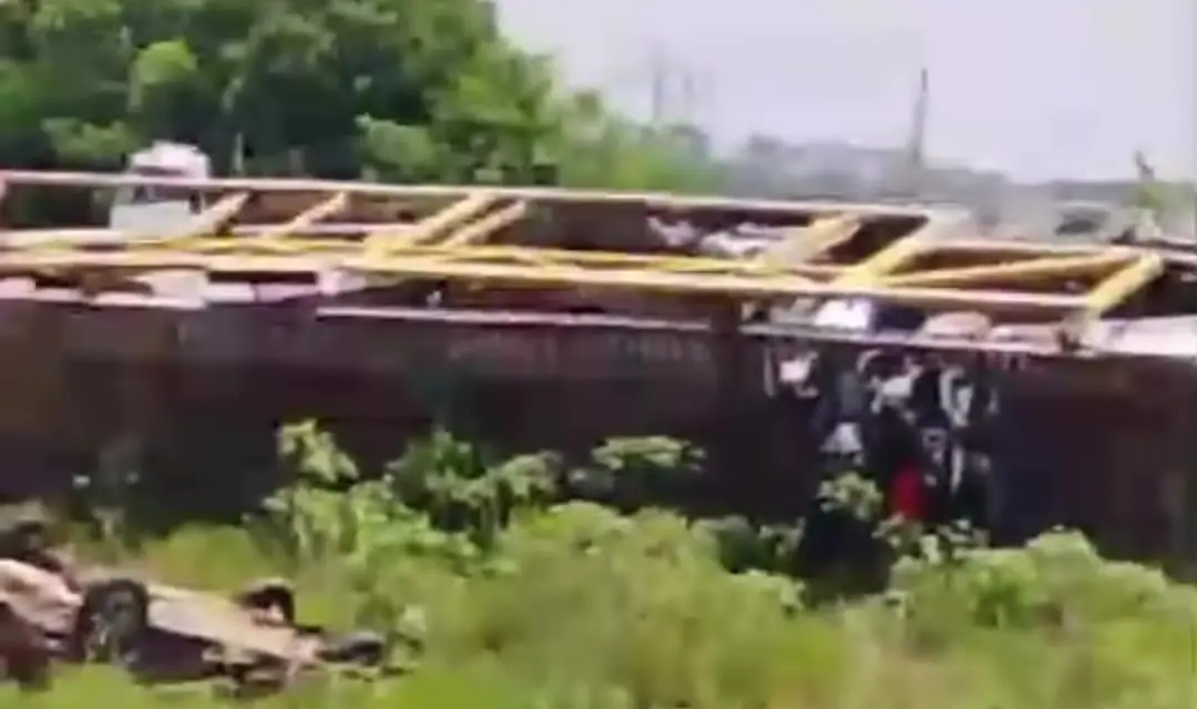 Rampas amarelas da carreta caídas no capim e carro de rodas para cima no terreno onde a cegonha tomba em Brejo Bonito