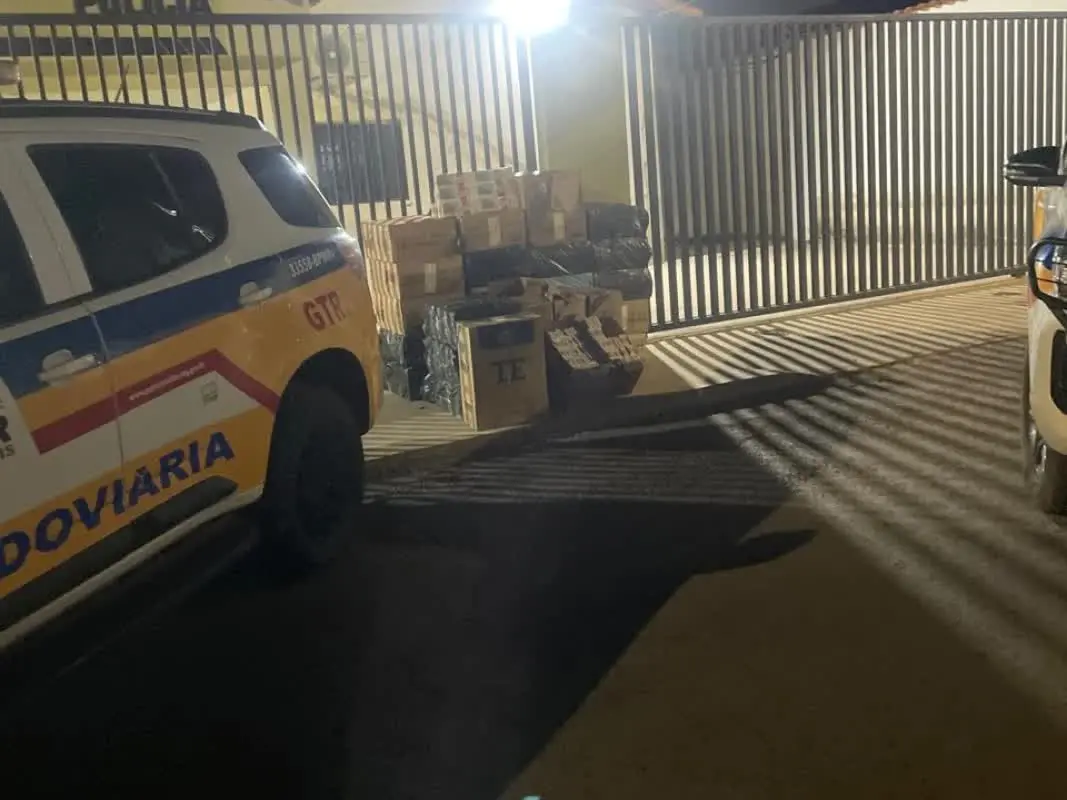 Caixas de cigarros contrabandeados apreendidas ao lado de viatura da Polícia Militar Rodoviária