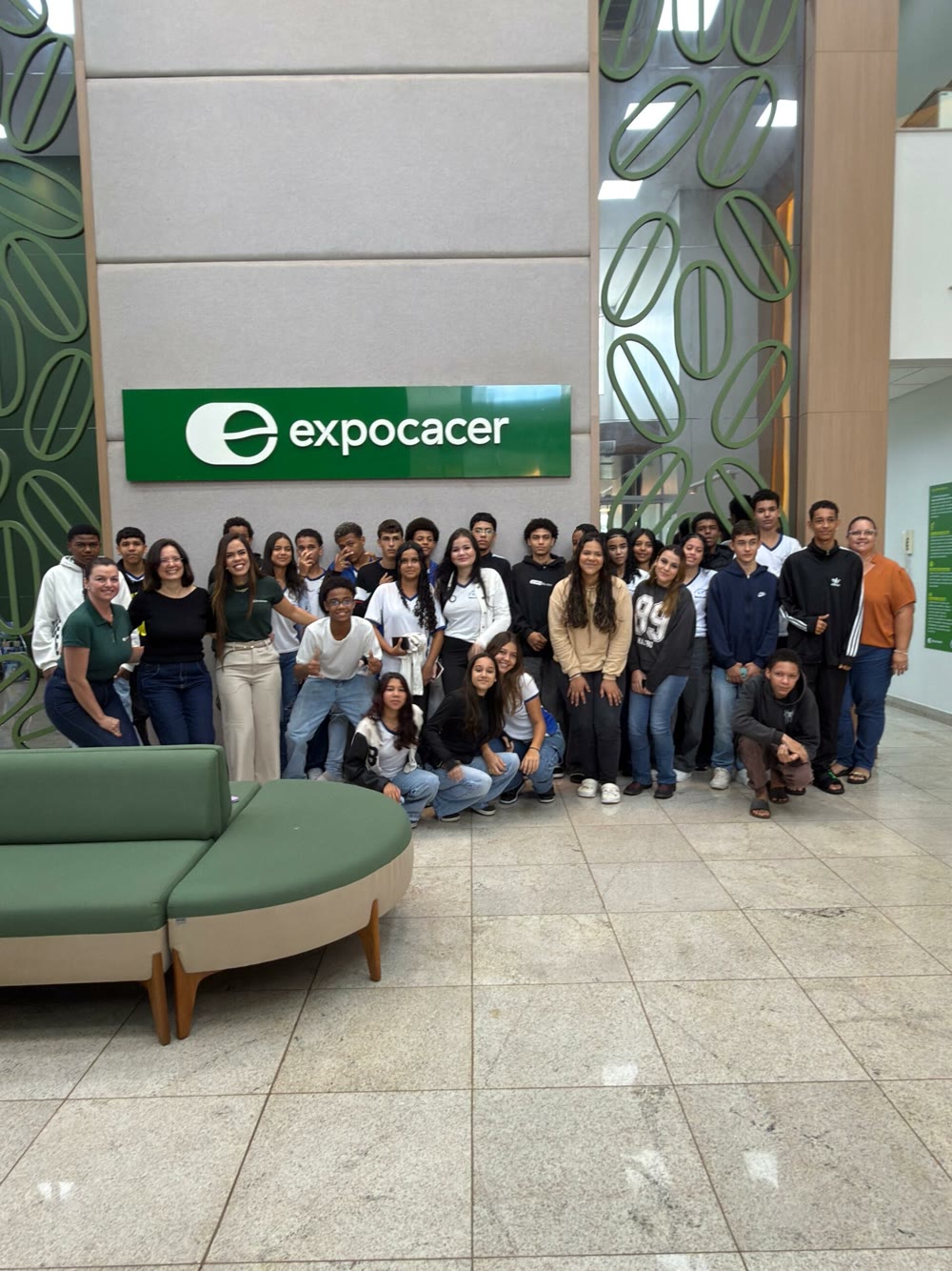 Alunos do ensino médio posam diante do letreiro da Expocacer durante visita do projeto das redações sobre café