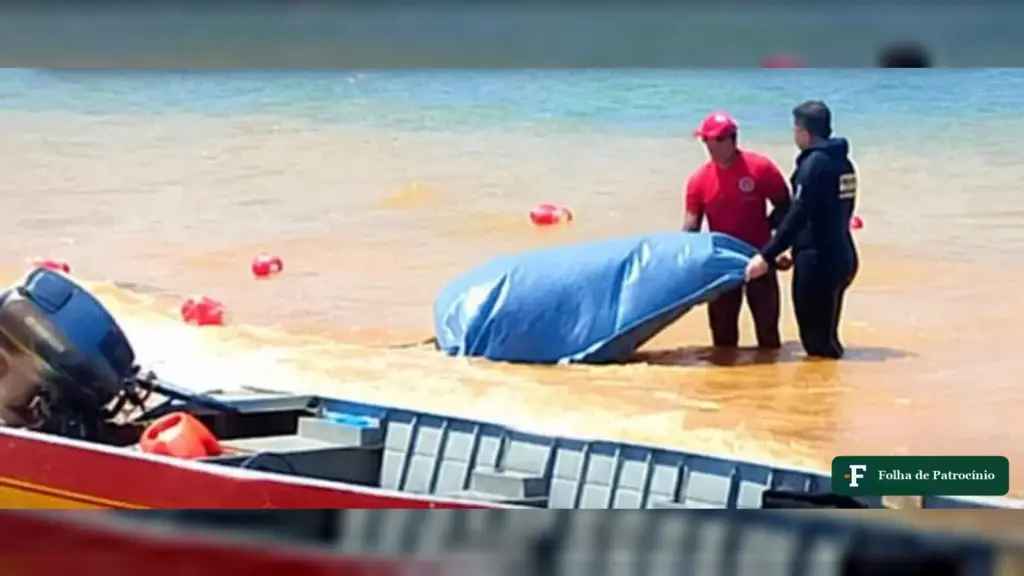 Equipe no raso da represa com lona azul sobre o corpo encontrado em Três Marias