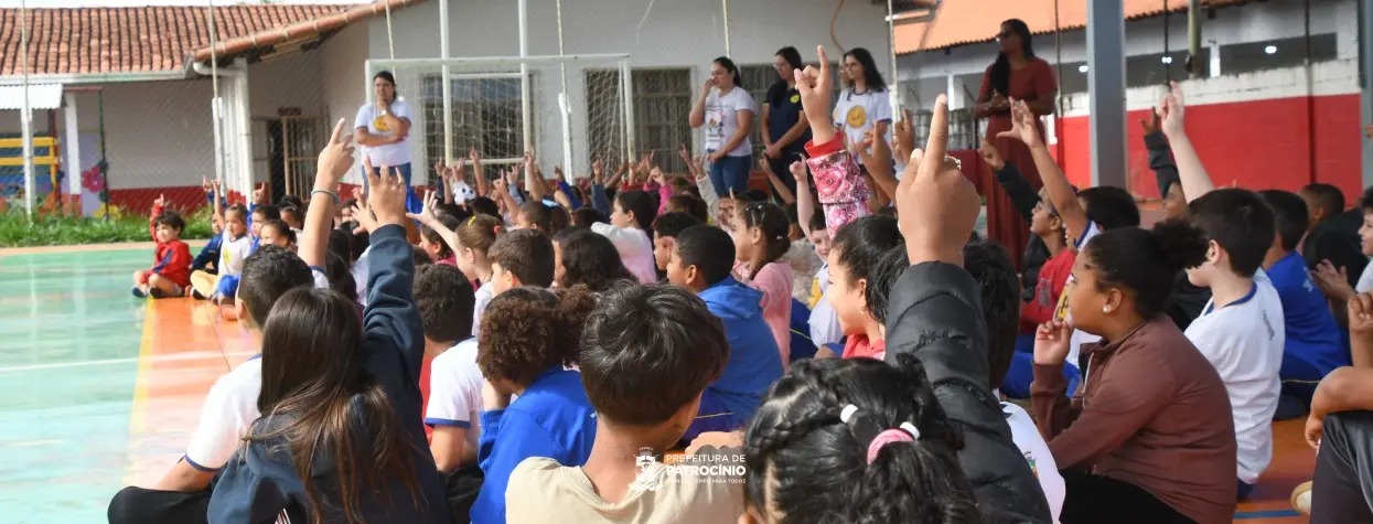 Crianças sentadas em roda com professoras em pátio de unidade de ensino da rede municipal, como a Creche Boa Vista