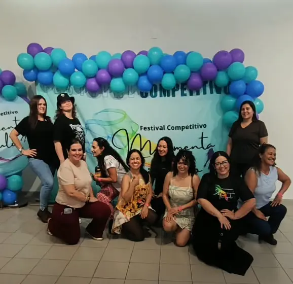 Grupo de mulheres de roupa comum posa diante do painel com balões do Festival Movimenta Triângulo
