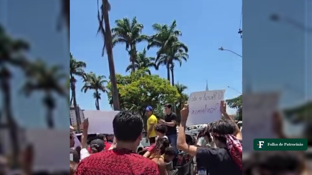 Grupo de manifestantes com cartazes em avenida de Patos de Minas durante a confusão entre atos de campanha