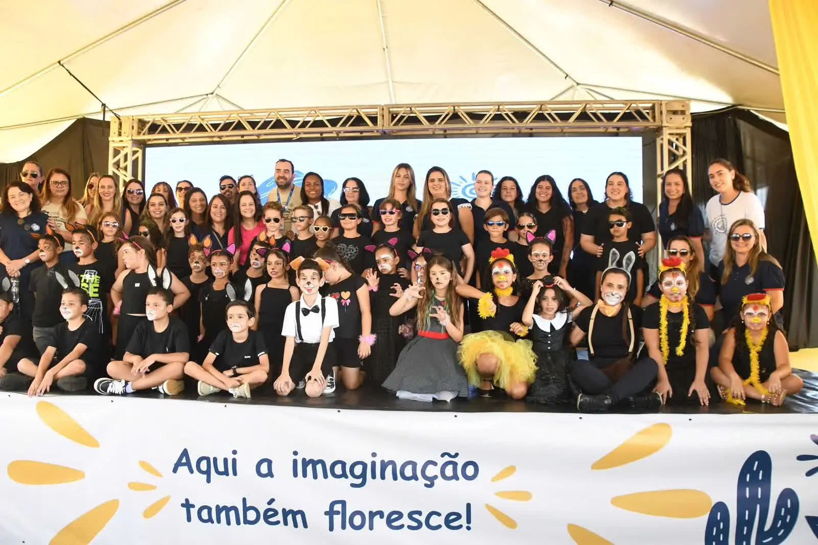 Crianças e educadores no palco do 1º Festival Literário, na Praça da Bíblia, em Patrocínio, antes do Dia das Crianças em Patrocínio
