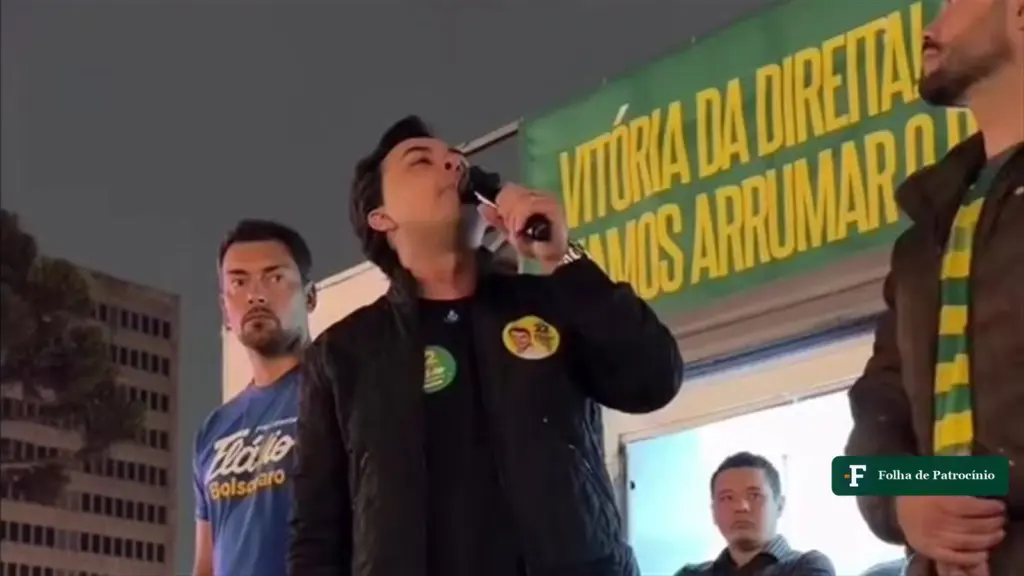 Discurso de Chiquini: o deputado eleito fala ao microfone num palanque com a faixa Vitória da direita, no Paraná