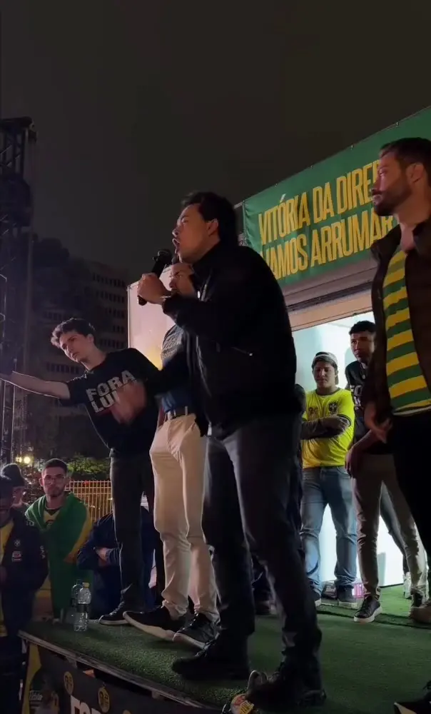 Discurso de Chiquini no palanque, cercado de apoiadores com camisetas Fora Lula