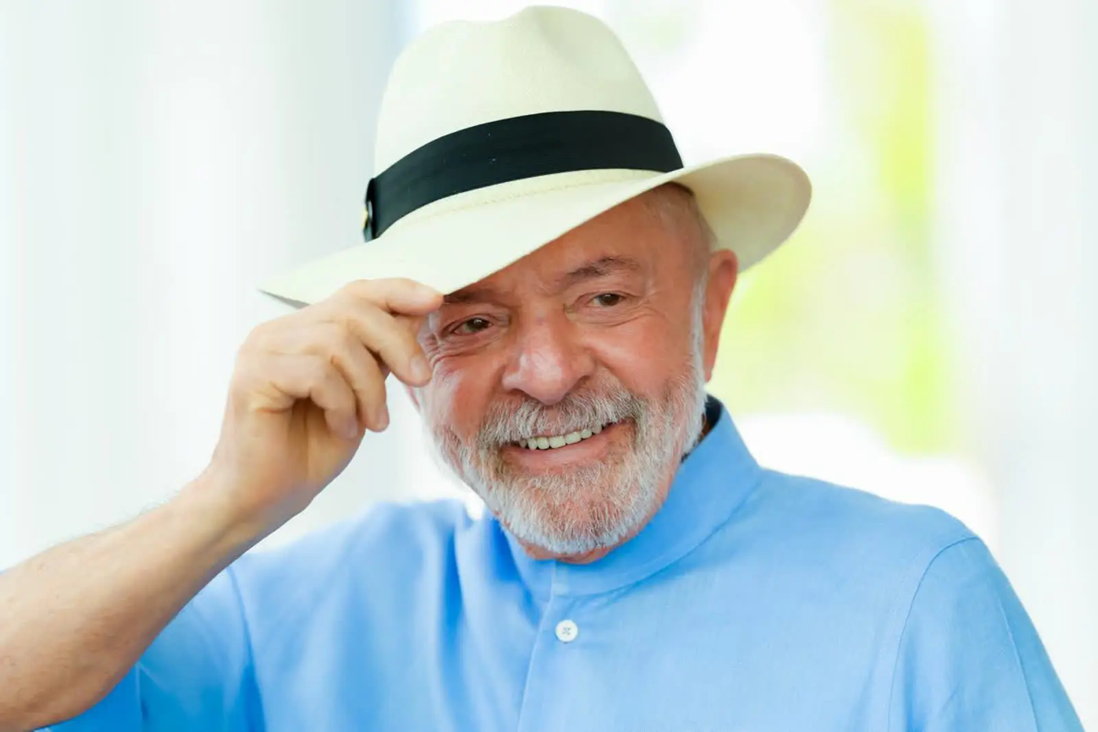 Presidente Lula de chapéu, sorrindo, em foto de julho de 2026, na matéria sobre a dívida de Minas