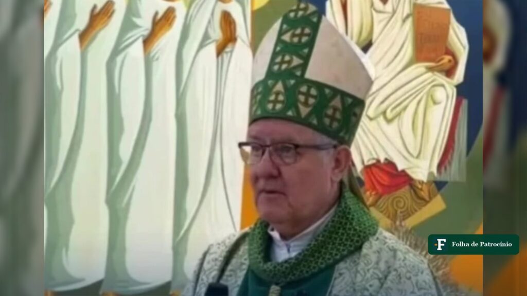 Dom Adair critica católicos em homilia, de mitra verde diante de um painel com figuras de santos