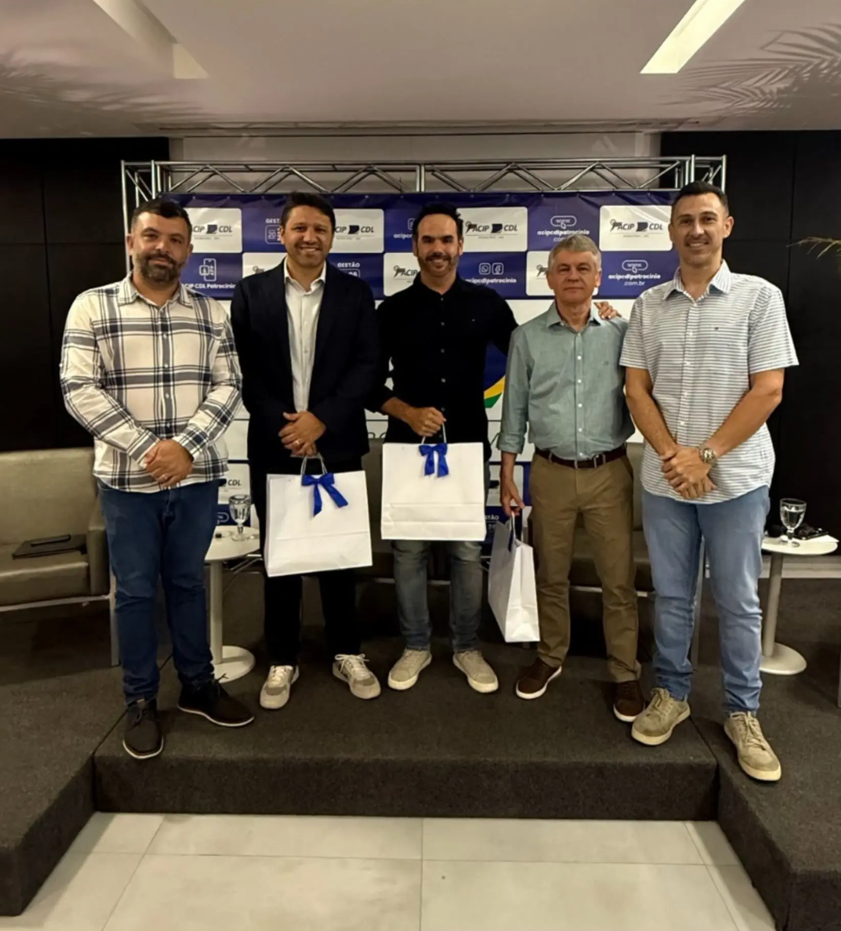 Participantes do painel posam juntos no palco ao fim do encontro na ACIP/CDL