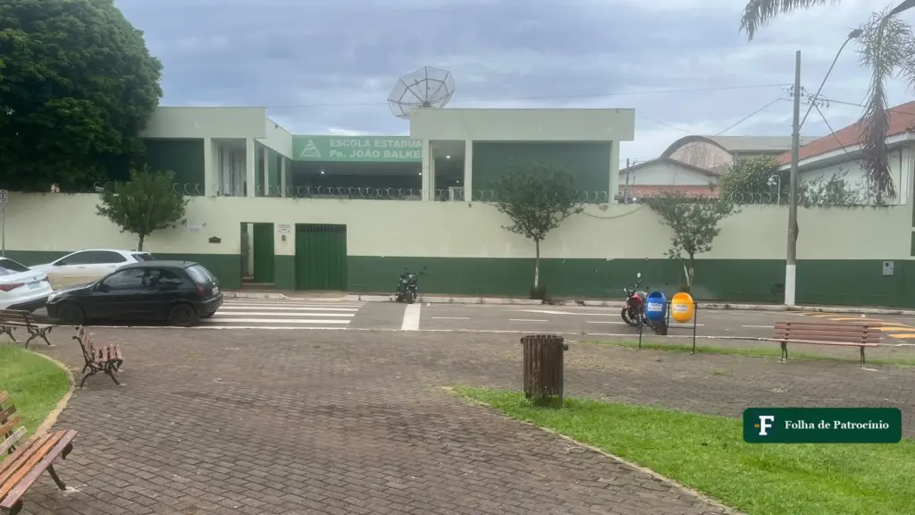 Fachada da Escola Padre João Balker, em Perdizes, vista da praça em frente, com a placa da escola estadual no alto do muro