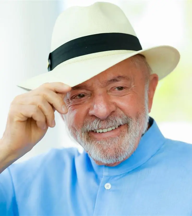 Lula sorri e toca a aba do chapéu em foto de 9 de julho de 2026, na matéria sobre a escolaridade de Lula