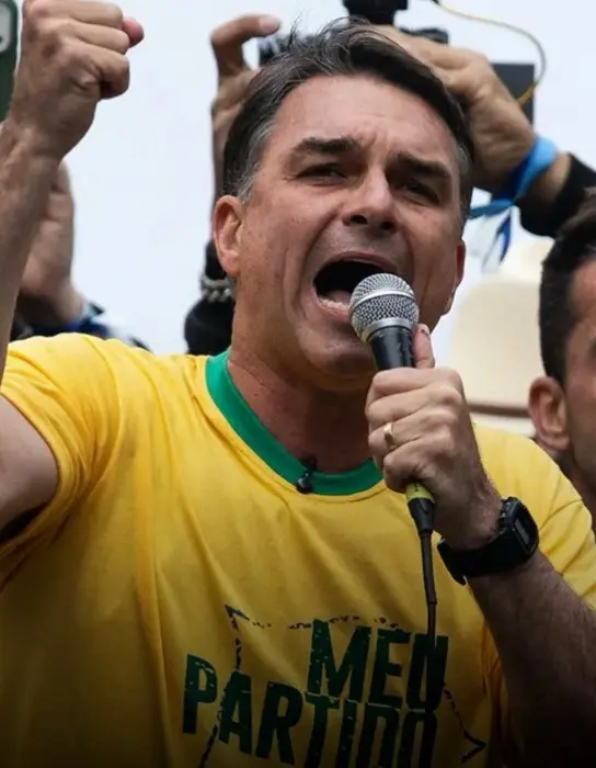 Flávio Bolsonaro discursa com microfone em ato de campanha, antes da gravação de Flávio com sertanejos em Goiás