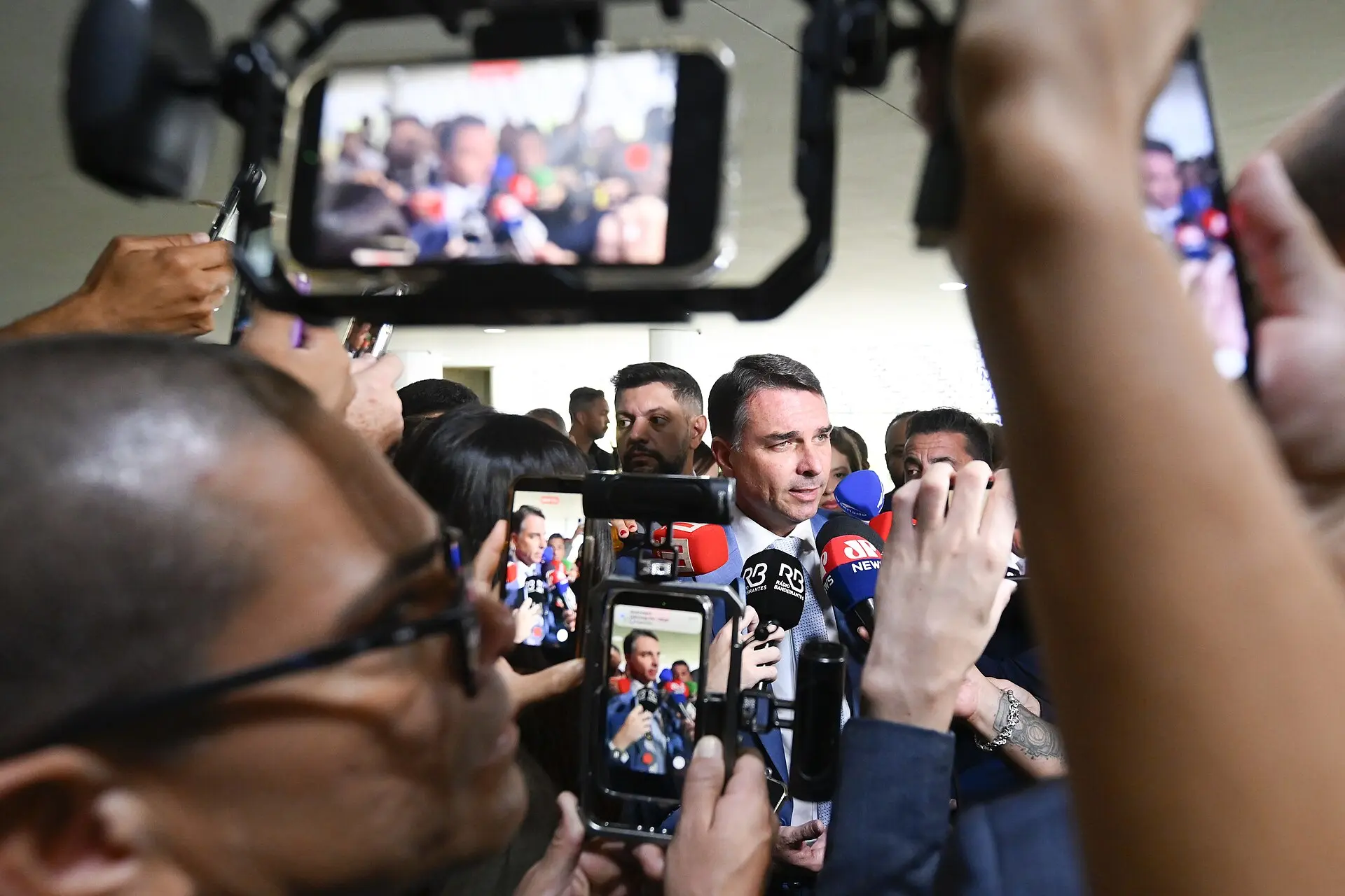 Flávio Bolsonaro cercado de jornalistas no Senado, no caso em que Flávio não entregou os passaportes