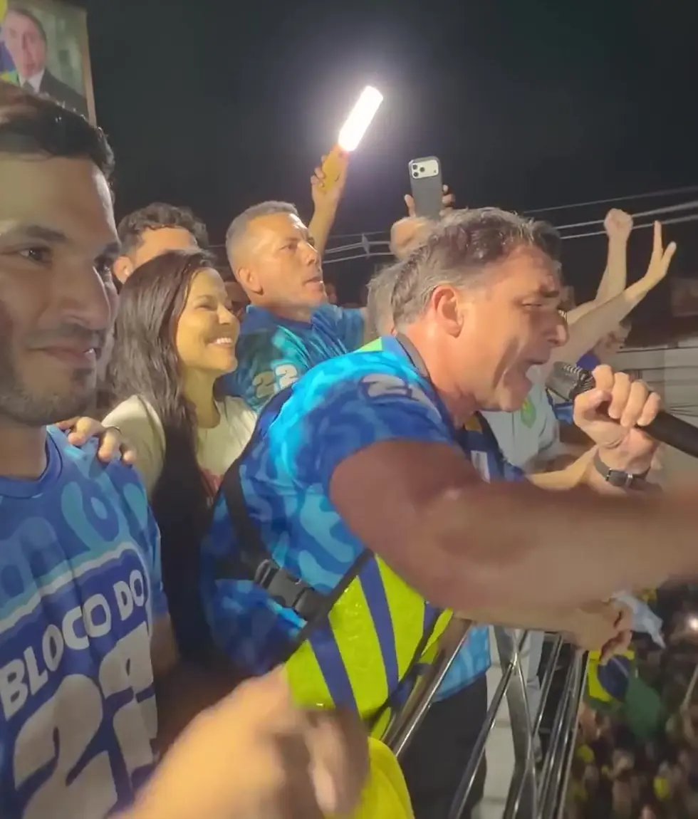 Flávio Bolsonaro, que prometeu aposentar Lula, canta com apoiadores no trio do Bloquinho do 22 em Fortaleza, com a multidão ao fundo