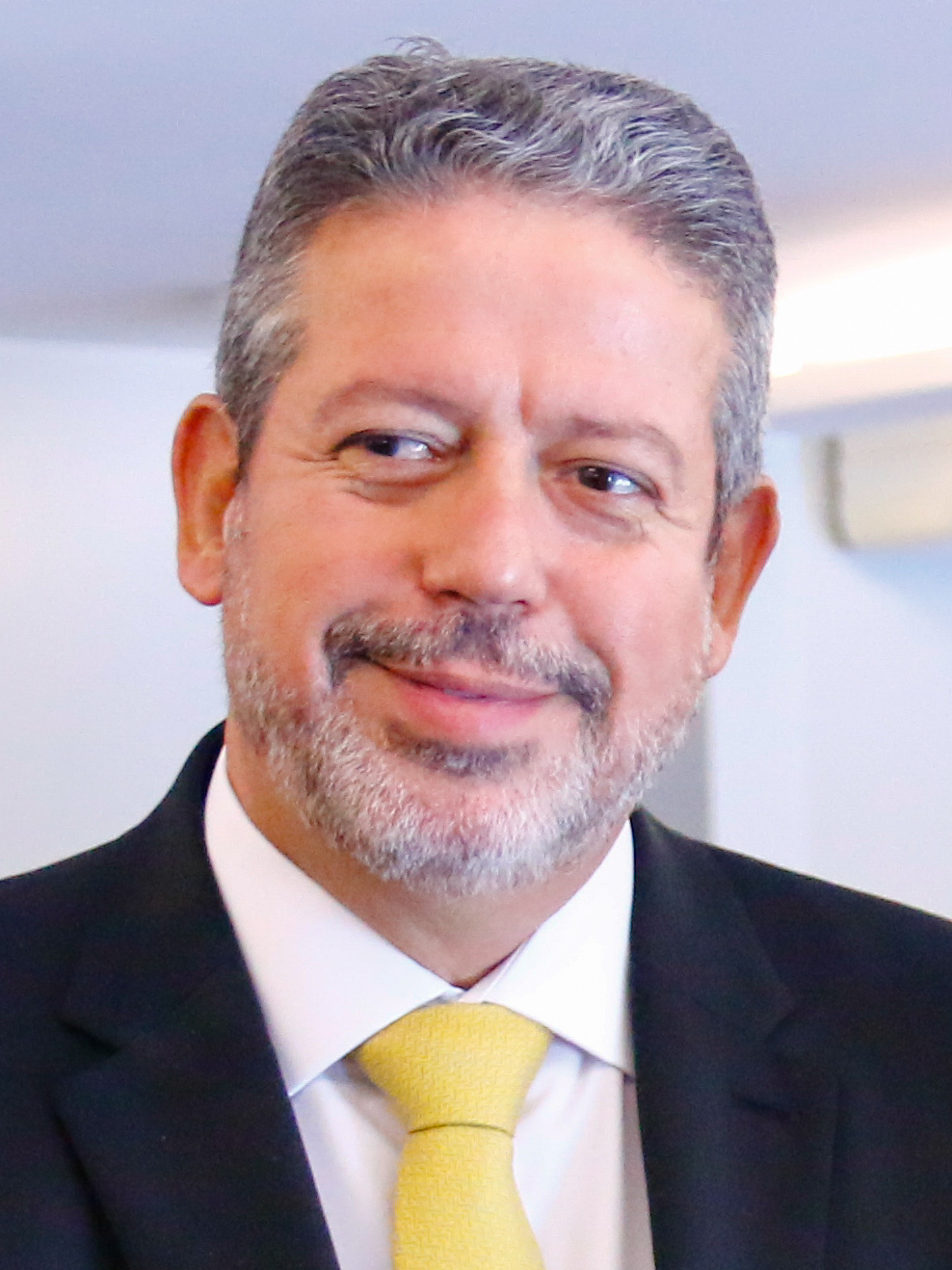 Arthur Lira, um dos senadores eleitos em Alagoas, sorri de terno e gravata amarela na Câmara dos Deputados