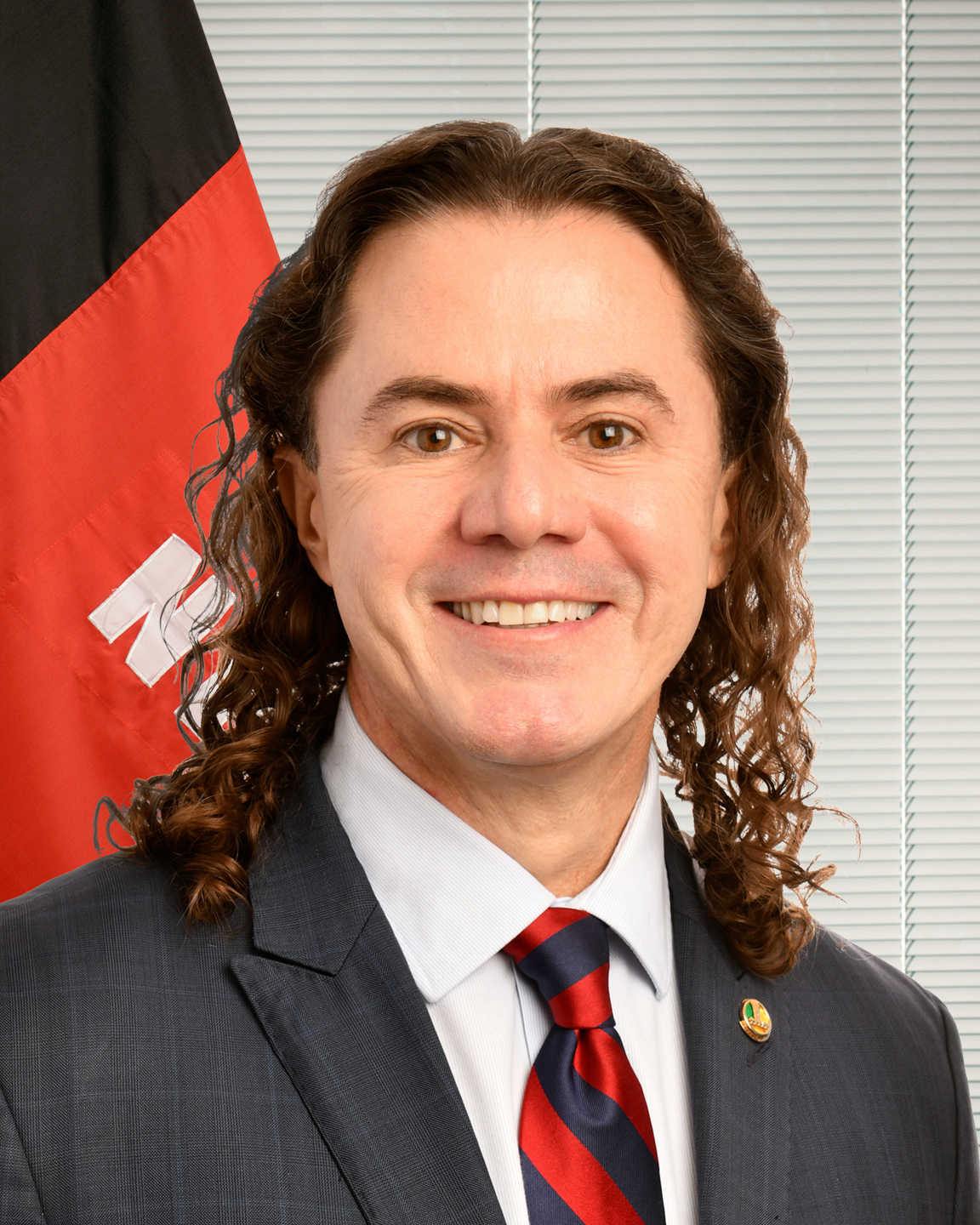 Veneziano Vital do Rêgo, um dos senadores eleitos na Paraíba, em retrato oficial do Senado com a bandeira do estado ao fundo