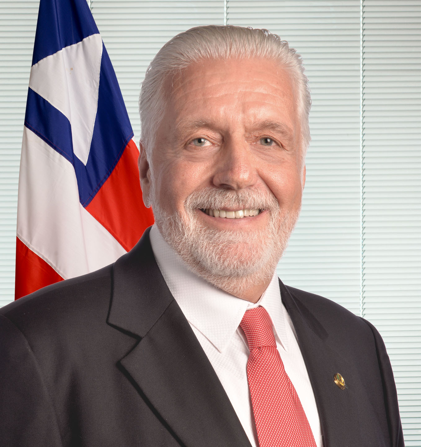 Jaques Wagner, um dos senadores eleitos na Bahia, em retrato oficial do Senado com a bandeira da Bahia ao fundo
